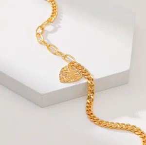 Detailaufnahme des goldenen Herzanhängers mit Zebra-Textur und Zirkon auf Gliederkette