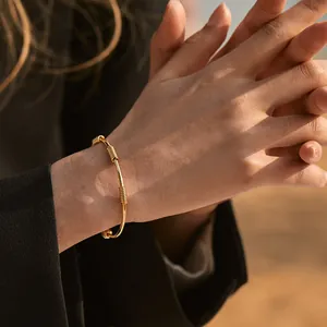 Detail of 18K gold-plated brass bracelet with wire-wrapped design and polished finish