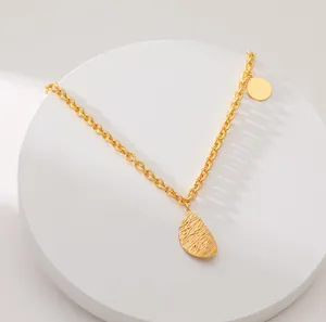 Schicke 18K Goldkette mit strukturiertem Oval-Anhänger auf weißem Sockel präsentiert