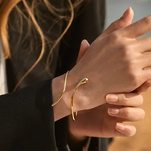 Polished 18K gold-plated brass open cuff bracelet featuring a minimalist snake-shaped design