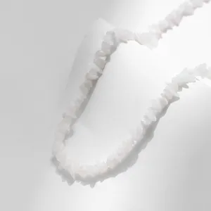 Detailopname van een handgemaakte boho-ketting met onregelmatige witte kristallen