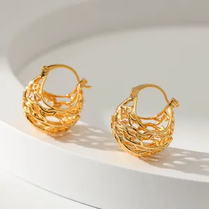 Golden hollow woven sphere hoop earrings with textured 18K brass finish on white display