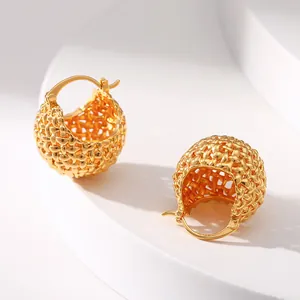 Macro shot of 18K gold plated hollow woven ball earrings with detailed brass texture