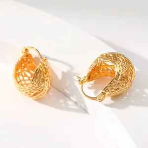 Detailed view of woven hollow ball gold earrings with 18K brass texture on white stand