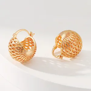 Detailed macro shot of 18K gold hollow mesh ball hoop earrings with textured metal design