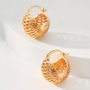 Macro detail of gold-plated hollow basket-weave texture earrings with a semi-sphere design