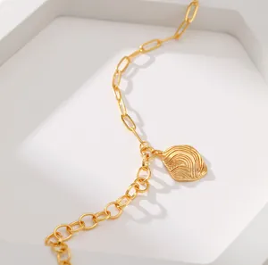 Detail einer Goldhalskette mit zweifacher Gliederkette und gewelltem Anhänger