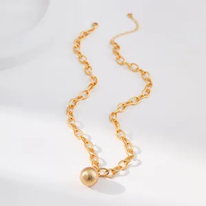 Detail einer klobigen Goldkette mit gebürstetem Metallkugel-Anhänger und Verschluss