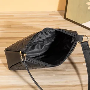 Borsa a spalla trapuntata nera con dettagli dorati e vista interna su tavolo