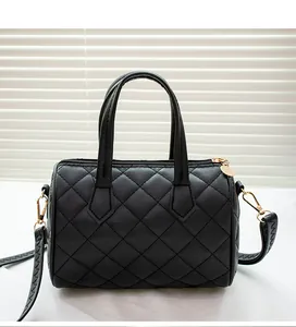 Macro detail of black quilted Boston bag with gold hardware and leather texture