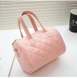 Detail of pink quilted boston bag showing diamond pattern stitching and gold hardware