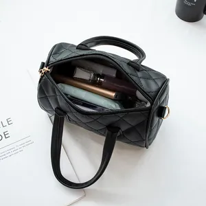 Black quilted cylinder handbag showing spacious interior with personal essentials