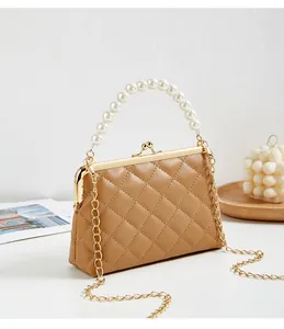 Detail van de camel gewatteerde tas met gouden sluiting en elegant parelhandvat