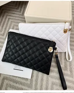 Détail des pochettes matelassées noir et blanc avec fermoirs dorés et dragonnes