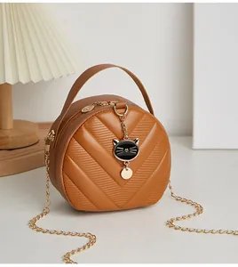 Detail der gesteppten Halbrundtasche mit Katzenanhänger und goldener Kette