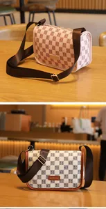 Detalle del bolso bandolera a cuadros rosa con correa ancha ajustable y logo de marca