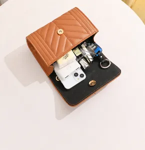 Interior view showing the storage capacity of the tan V-quilted chain crossbody bag
