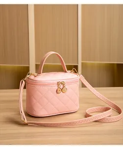Détail du sac à cosmétiques rose matelassé avec doubles fermetures éclair dorées