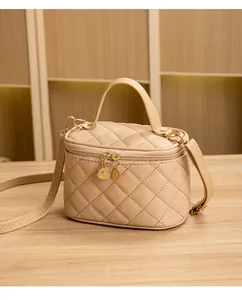 Détail du sac à cosmétiques beige matelassé avec double fermeture éclair dorée