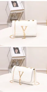 Close-up of white V-quilted crossbody bag with gold tassel and metal chain strap details