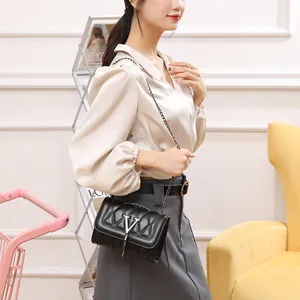 Sac bandoulière matelassé noir élégant avec logo V argenté et bandoulière chaîne sur modèle