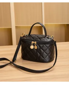 Détail du sac à maquillage noir matelassé avec ferrures dorées et double fermeture