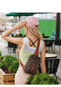 Mannequin portant un sac de poitrine à damier avec des détails de quincaillerie dorée