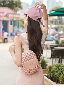 Détail du sac de poitrine rose à carreaux avec boucles dorées et bandoulière
