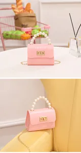 Mini bolso rosa con textura de cocodrilo, elegante asa de perlas y cierre dorado