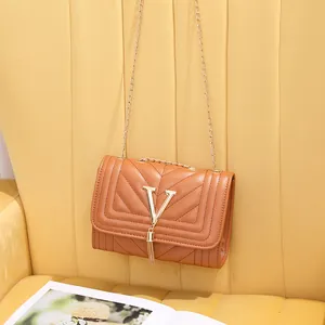 Quilted V-pattern crossbody bag with gold chain strap and stylish tassel detail