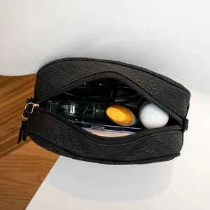 Top view of a black woven crossbody bag showcasing internal storage for essentials