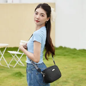 Minimalist black crossbody square bag with ripple stitching and decorative woven strap