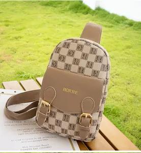 Détail du tissu jacquard à carreaux anglais et boucle dorée sur un sac de poitrine bandoulière
