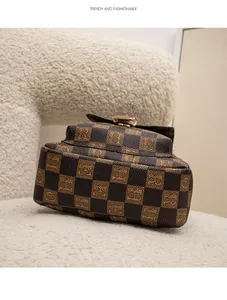Détail d'un sac de poitrine vintage à damier avec boucle métallique sur un tissu en peluche
