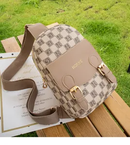 Détail du sac bandoulière vintage beige à motifs et cuir marron sur un banc