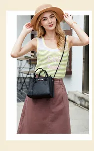Vista street style di una mini borsa in pelle nera con motivo litchi e logo dorato