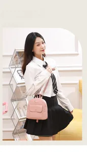 Detailed view of pink mini backpack with embossed flower pattern and gold snap button