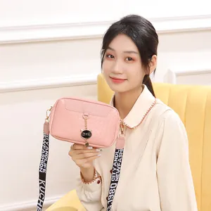 Petit sac bandoulière rose avec texture tressée, pendentif chat et sangle large