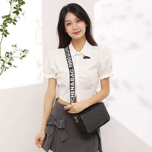 Petit sac carré noir à pois avec large bandoulière ajustable porté par un mannequin