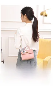 Pink woven texture crossbody bag with floral scarf handle and gold chain strap detail