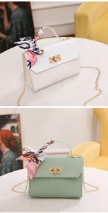 Detail of woven square bags with silk scarves and gold chain straps in white and green