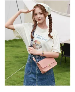 Pink woven flap crossbody bag with golden buckle and sporty ribbon strap on model