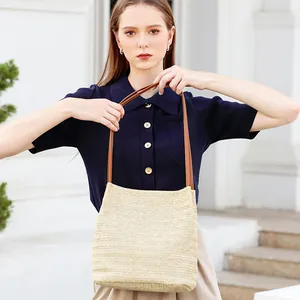 Chic woven straw bucket bag with brown leather straps for summer casual vacations