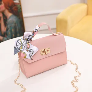 Pink woven chain crossbody bag with a decorative silk scarf and gold twist lock