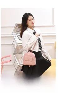 Close-up of pink leather mini backpack with embossed heart pattern and gold metal trim