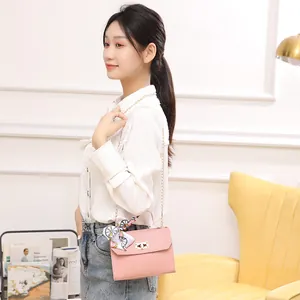 Pink quilted crossbody bag with decorative silk scarf and gold chain strap for women