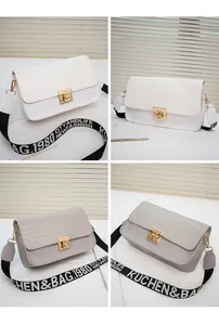 Detail of woven texture flap and golden rotating metal lock on stylish crossbody bags