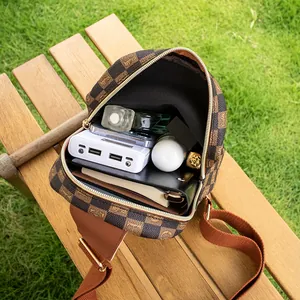 Sac de poitrine à damier marron avec objets du quotidien à l'intérieur sur un banc