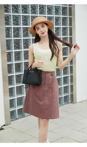 Dettaglio di una mini borsa nera a grana di litchi abbinata a gilet in maglia e cappello