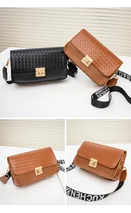 Detail of woven flap crossbody bag with wide letter-print strap and gold buckle